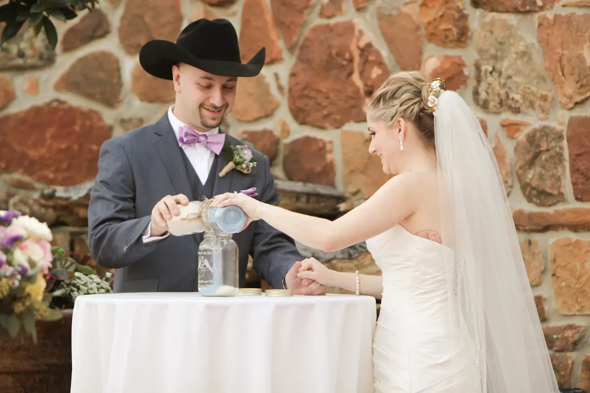 Alex and Jennifer pouring the unity sand at their wedding ceremony