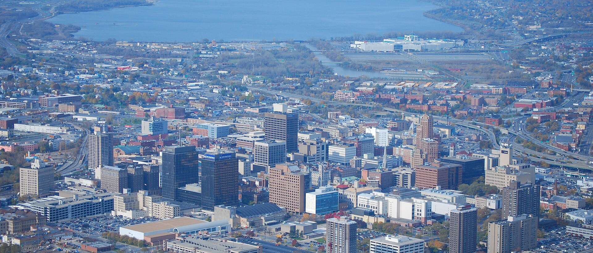 Aerial view of downtown Syracuse, NY with Onondaga Lake in the distance